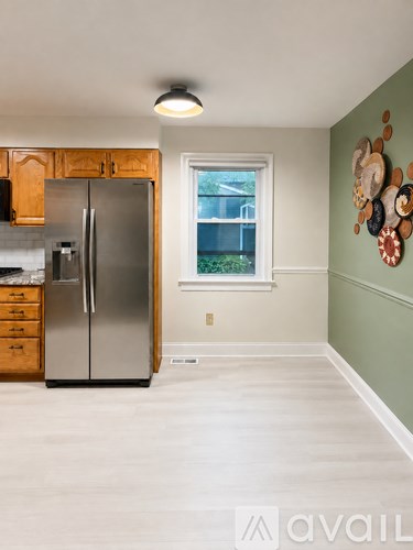 A kitchen with a refrigerator and a wall decoration.