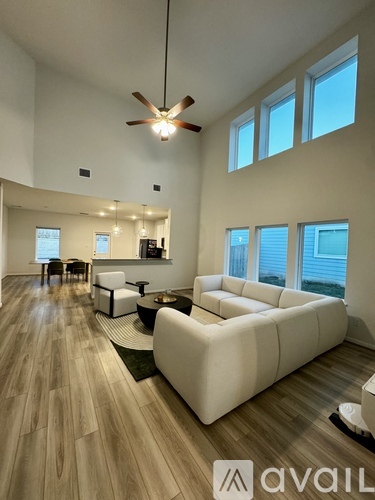 A living room with a white couch and a ceiling fan.