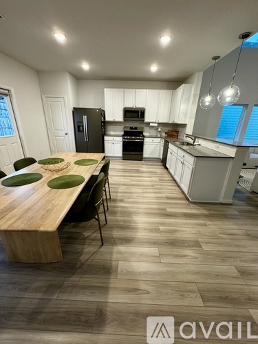A kitchen with a table and chairs in front of it.