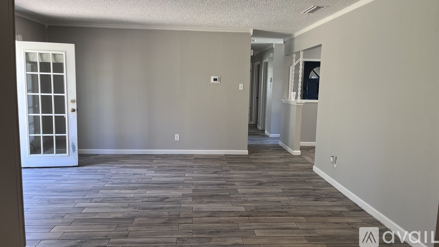 A room with wooden flooring and a white door.