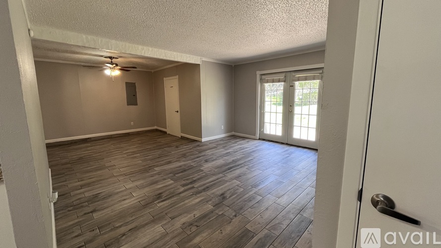 A room with wooden flooring and a ceiling fan.