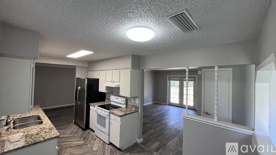 A kitchen with a granite countertop and stainless steel appliances.