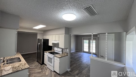 A kitchen with a granite countertop and stainless steel appliances.