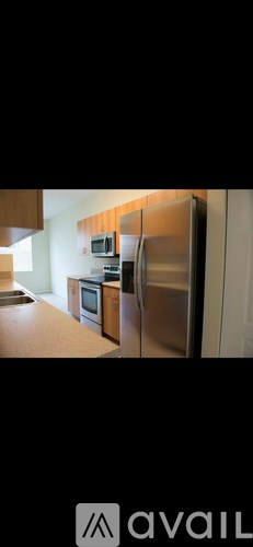 A kitchen with a refrigerator, microwave, and oven.