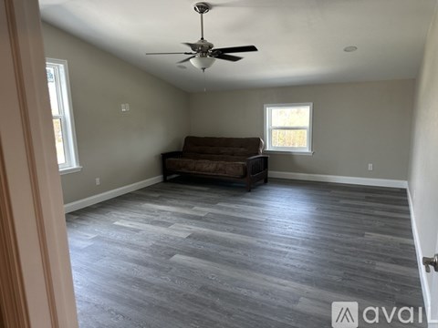A living room with a couch and a ceiling fan.