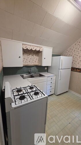 A small kitchen with a stove, sink, and refrigerator.