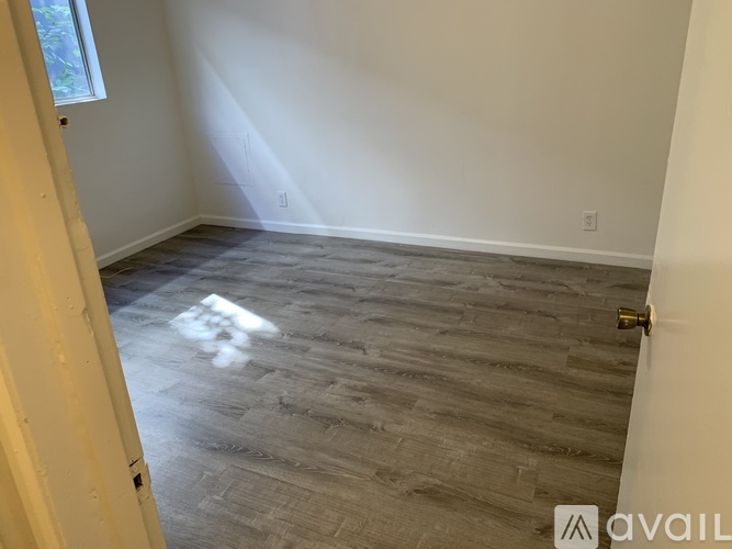 A room with a wooden floor and a white door.