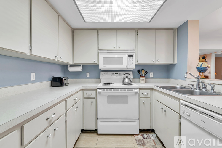 A kitchen with white cabinets and appliances.