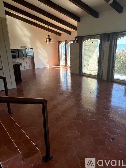 A large open space with a staircase and a glass door leading outside.