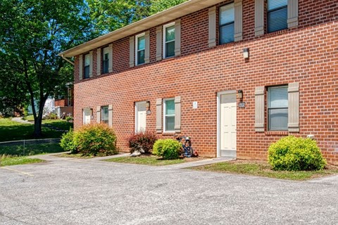 A red brick building with a white door and windows.