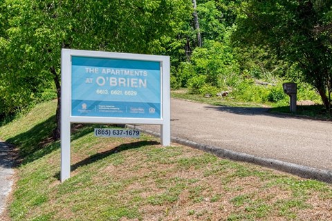 A sign for The Apartments at O'Brien with a phone number on it.