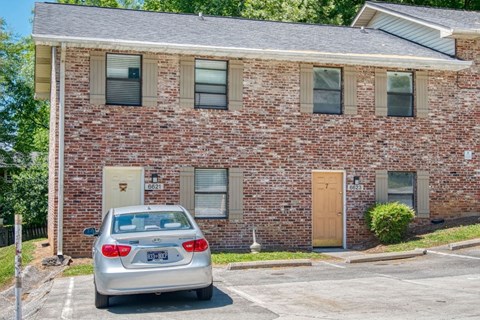 A brick building with a car parked in front.