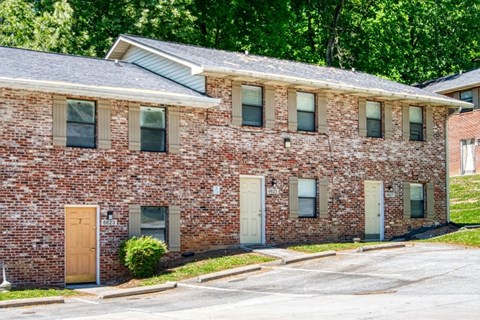 A red brick building with a brown door and windows.