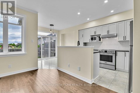 A kitchen with white cabinets and a stove top oven.