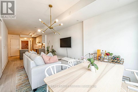 A well-lit living room with a white sofa and a wooden dining table.