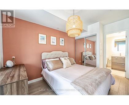 A bedroom with a large bed and a wooden nightstand.