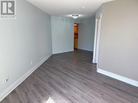 A room with wooden flooring and white walls.