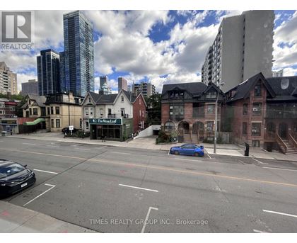 A city street with a blue car parked on the side.