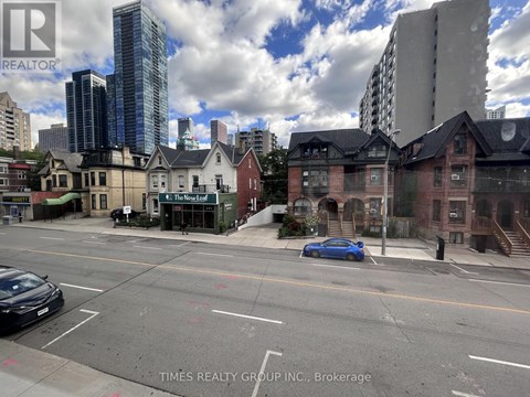 A city street with a blue car parked on the side.