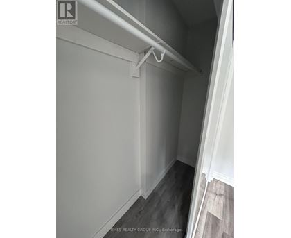 A white closet with a white shelf and a white door.