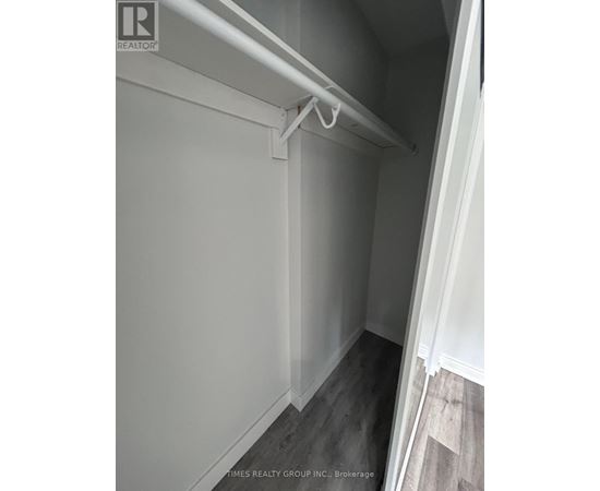 A white closet with a white shelf and a white door.