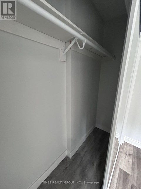 A white closet with a white shelf and a white door.