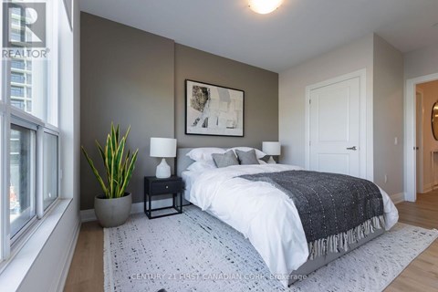 A bedroom with a large bed and a potted plant.
