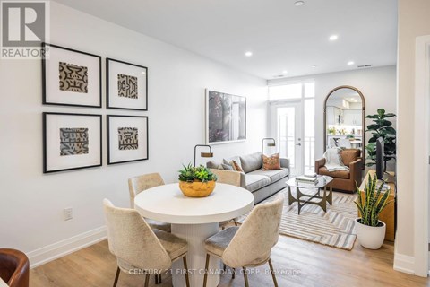A well-lit dining room with a white table and chairs.