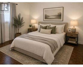 A bedroom with a large bed, two lamps, and a painting on the wall.