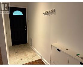 A hallway with a black door and a white cabinet.