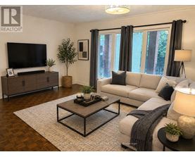 A living room with a grey couch, a wooden coffee table, and a television.