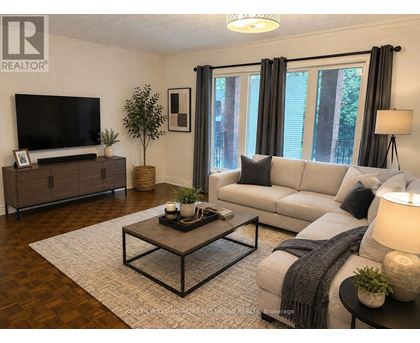 A living room with a grey couch, a wooden coffee table, and a television.