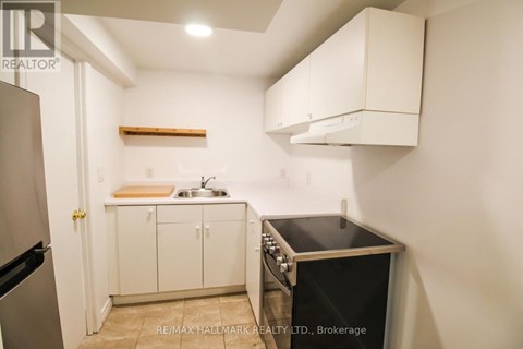 A small kitchen with a black oven and white cabinets.