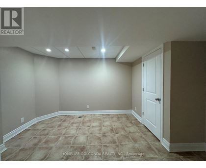 A room with a carpeted floor and a door on the right side.