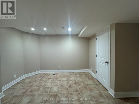 A room with a carpeted floor and a door on the right side.