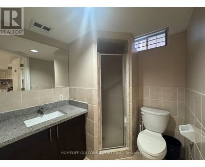 A bathroom with a toilet, sink, and shower.