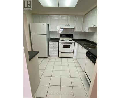 A kitchen with white cabinets and appliances.