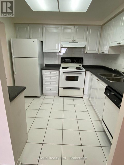A kitchen with white cabinets and appliances.