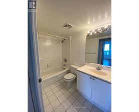 A white bathroom with a toilet, sink, and bathtub.