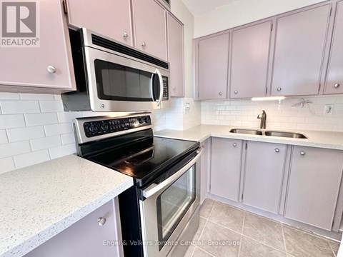 A kitchen with pink cabinets and a white countertop.