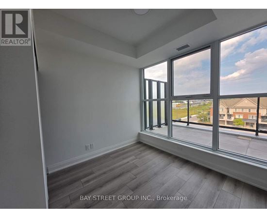 A room with a large window overlooking a residential area.