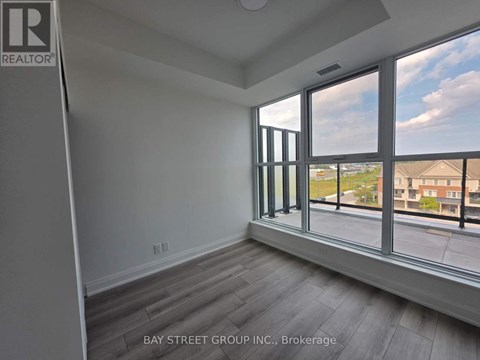 A room with a large window overlooking a residential area.