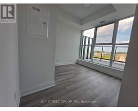 A room with a window overlooking a parking lot.