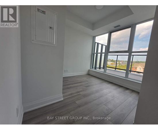 A room with a window overlooking a parking lot.