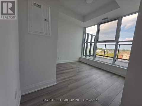 A room with a window overlooking a parking lot.
