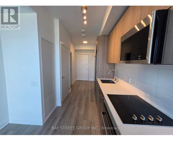 A modern kitchen with a stove top oven and a microwave above the sink.