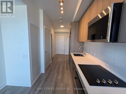 A modern kitchen with a stove top oven and a microwave above the sink.