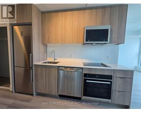 A modern kitchen with a refrigerator, sink, and oven.