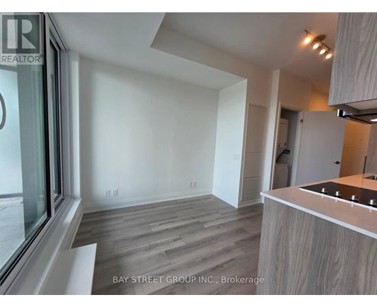 A modern kitchen with a wooden floor and white walls.