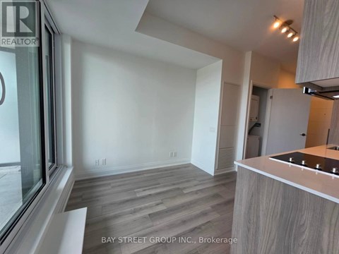 A modern kitchen with a wooden floor and white walls.